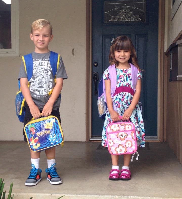 kids in backpacks with lunchboxes