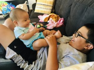 boy and baby, cuddling and smiling