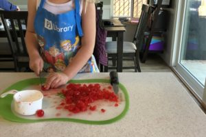 child chopping cherries