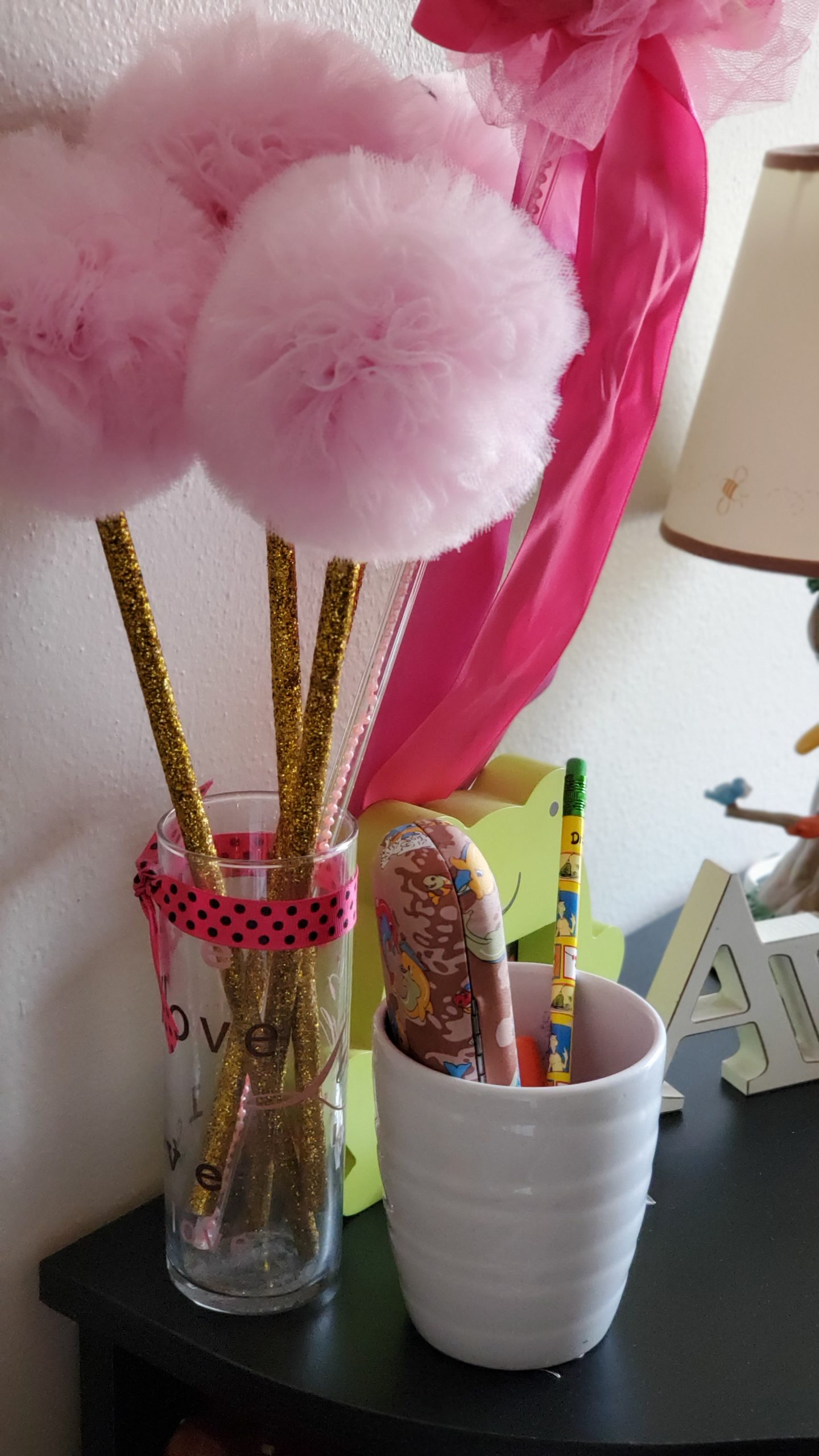 Personal touches on a desk space: handmade wands and a vase for pencils