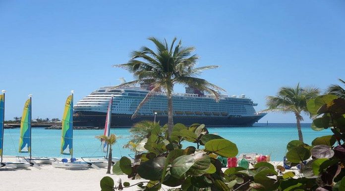 View from a beach of cruise ship docked in tropical port