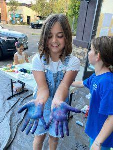 kid with paint on hand at seaside art center